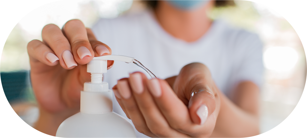 Pessoa de máscara utilizando álcool em gel