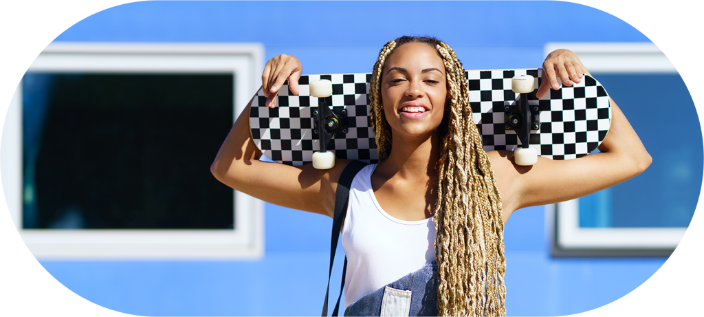 Mulher com tranças sorrindo e segurando um skate