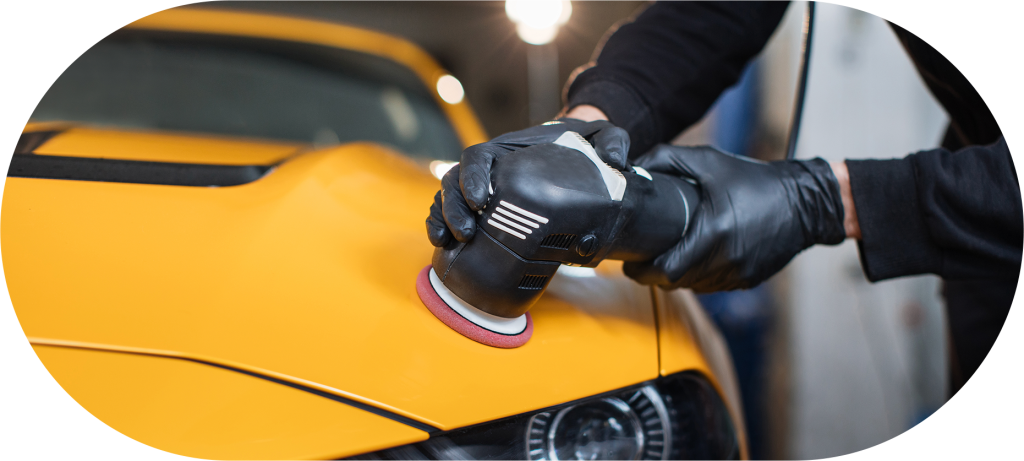 Profissional de luvas realizando polimento em automóvel