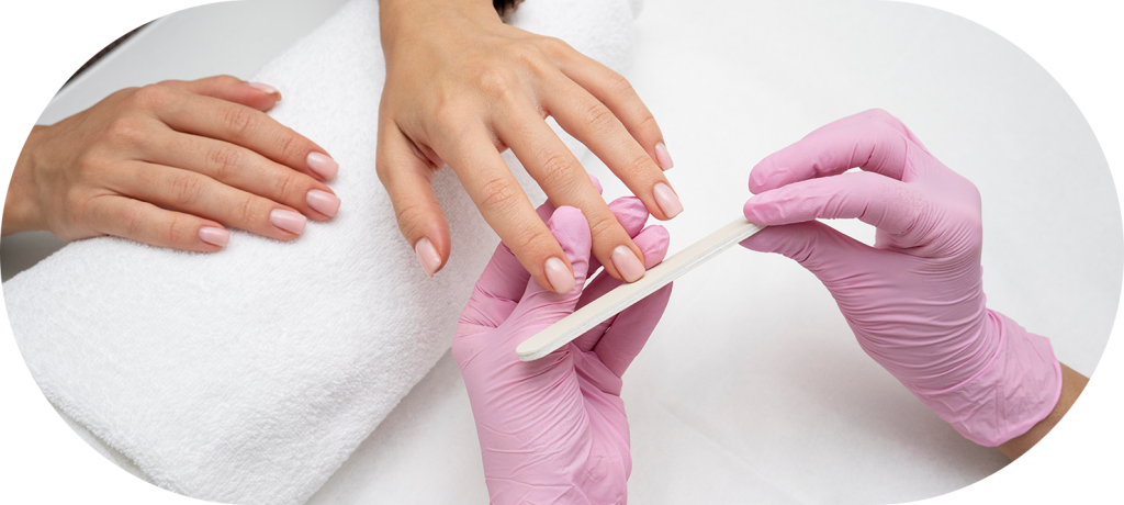 Manicure com luvas cor de rosa realizando atendimento