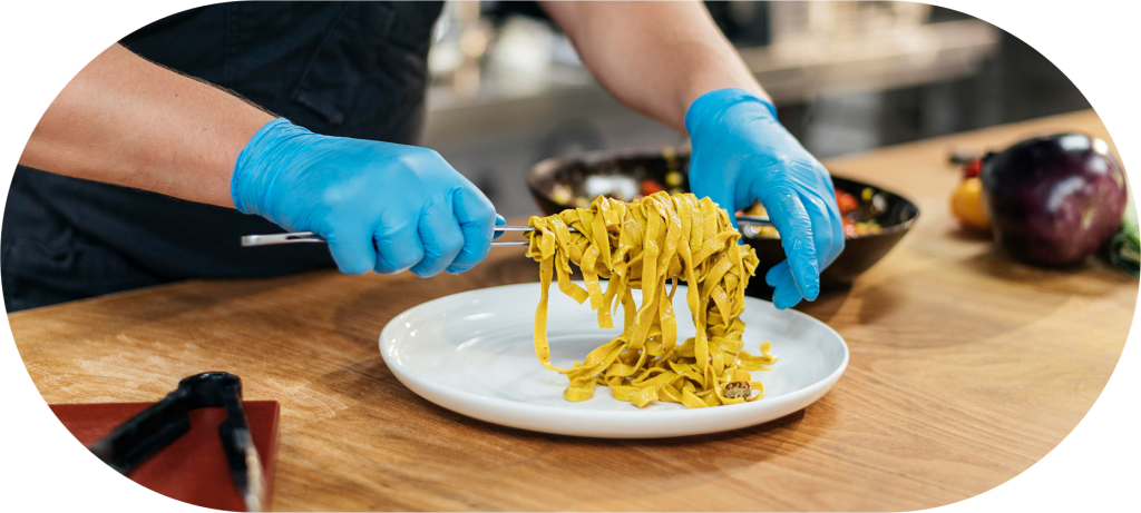 Profissional de cozinha empratando alimento 